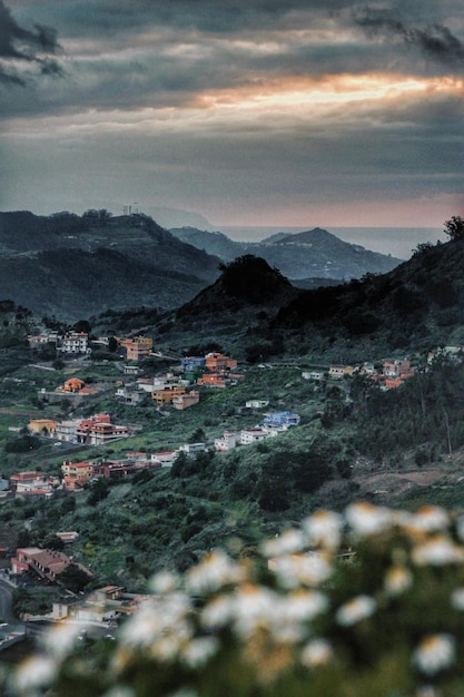 Casas na cidade pelas montanhas contra o céu nublado