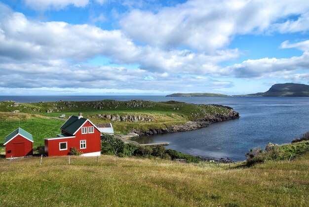 Casas na costa do mar em céu nublado em Torshavn, Dinamarca. Casas de madeira na vista do mar. Bela vista da paisagem. Férias de verão no país. Arquitetura e design. Ecologia e meio ambiente.