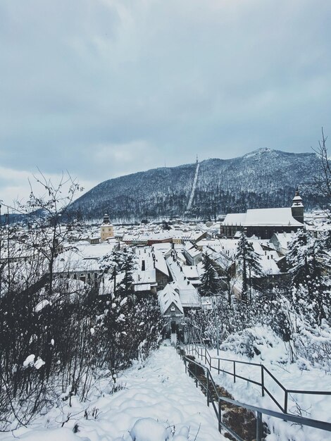 Casas de nieve cubiertas de edificios contra el cielo