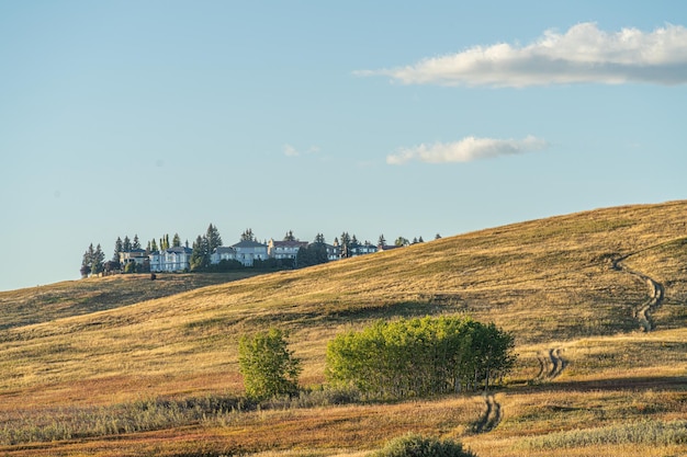 Casas no topo de uma colina com campos em primeiro plano