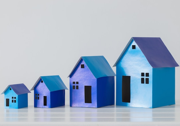 Foto casas de papel azul sobre fondo blanco.