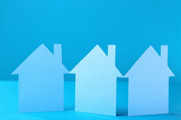 Casas de papel de color sobre fondo turquesa