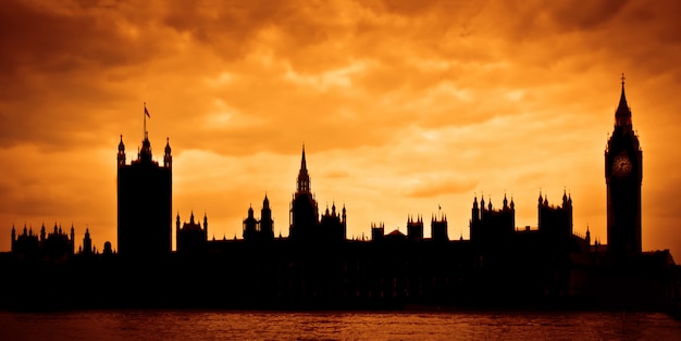 Casas del Parlamento al atardecer, silueta sobre cielo dramático