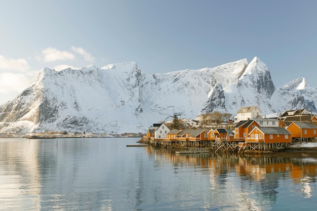 Casas en pilotes junto al lago contra montañas cubiertas de nieve