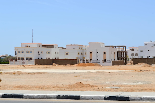 Casas rectangulares árabes blancas en el desierto con ventanas contra el fondo de arena amarilla