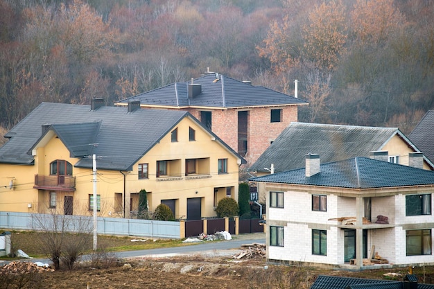 Casas residenciales con tejados cubiertos con tejas metálicas y cerámicas en zona suburbana rural.