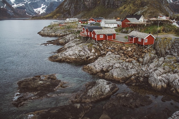 Casas rorbu na Noruega e montanhas rochosas sobre a paisagem do fiorde vista da viagem escandinava Lofoten