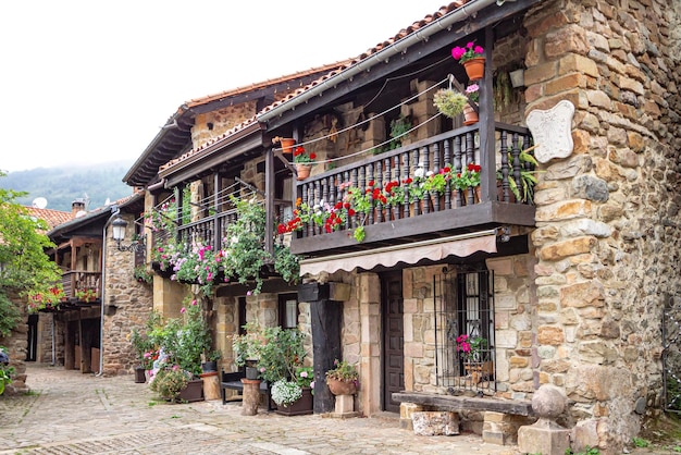 Casas tradicionales con flores en el balcón y un reloj de sol en la esquina