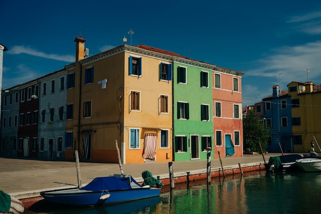 Casas vibrantes ao longo de um canal alinhado por barcos em burano, veneza, itália, em novembro de 2021