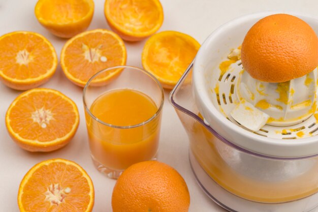 Casca de laranja fresca no espremedor. Copo de suco e laranja