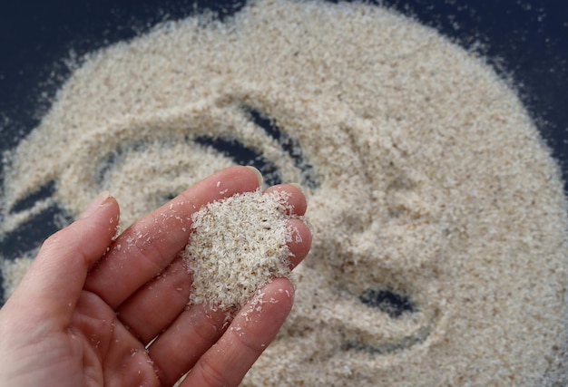 Foto casca de psyllium na mão de uma mulher foco seletivo