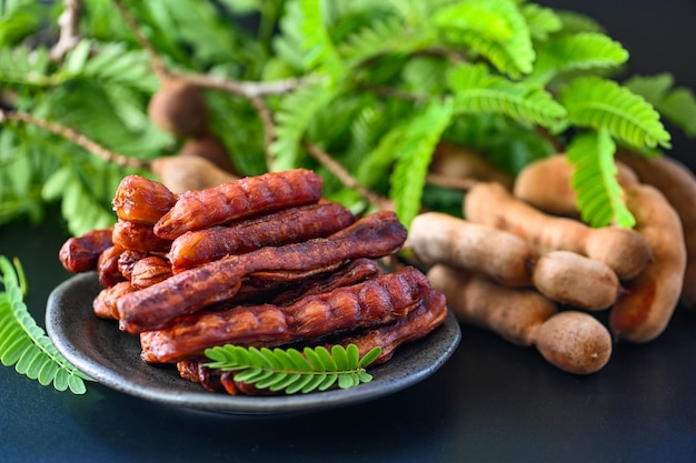 Casca de tamarindo em prato frutas tropicais verão Tamarindo doce para comida tamarindos maduros de frutas no prato e vista superior de fundo branco