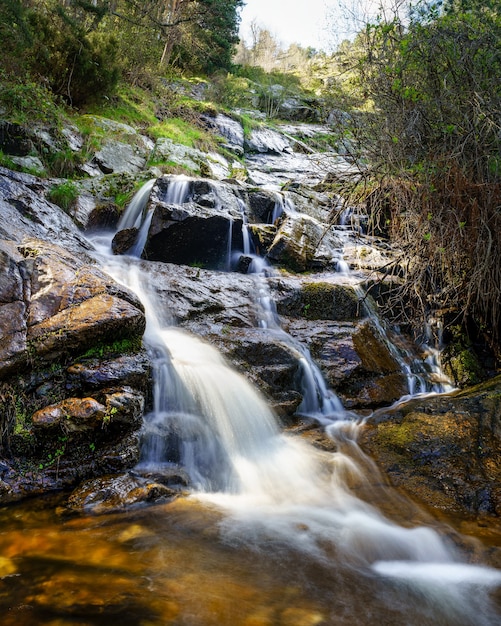 Cascada de agua dulce que baja de la montaña en foto de larga exposición