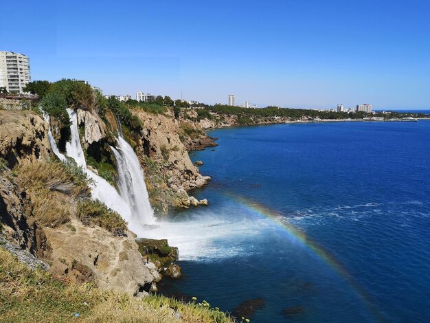 Foto la cascada de antalya duden un arco iris apareció frente a la cascada que se derramaba en el mar