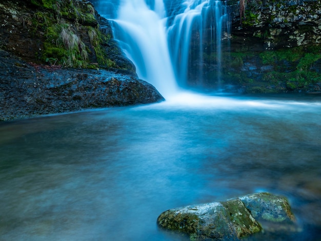 Cascada azul entre las montañas en una bonita mañana