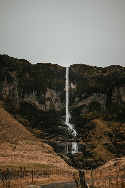 Cascada caída en Islandia sobre tierra negra con musgo