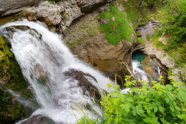 Cascada en dos caídas de la roca en paisaje soleado en el Pirineo de Ordesa.