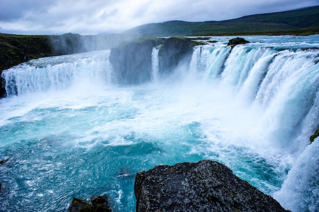 Cascada Godafoss con agua azul en paisaje de Islandia