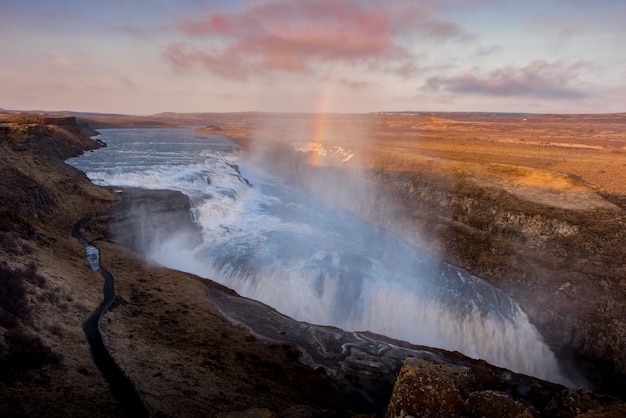 Cascada de Gullfoss en Islandia Puesta de sol con arco iris y día nublado