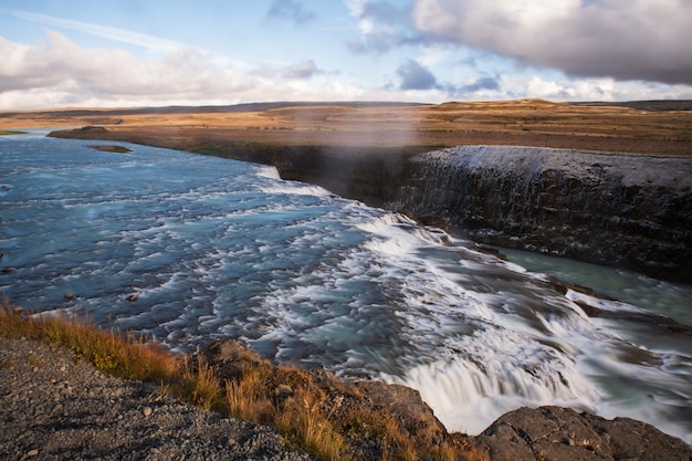 Foto cascada de gullfoss con nubes y cielo azul en islandia