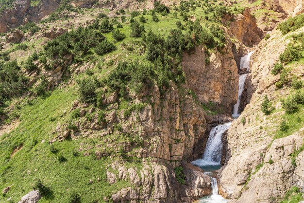 Cascada hermosa cascada en el paisaje de las montañas durante la puesta de sol