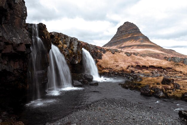 Foto una cascada en islandia con una montaña al fondo