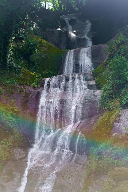 Una cascada de montaña fluye sobre las rocas Cascada de cascada en rocas cubiertas de musgo Vista de cascada de montaña Cascada de cascada