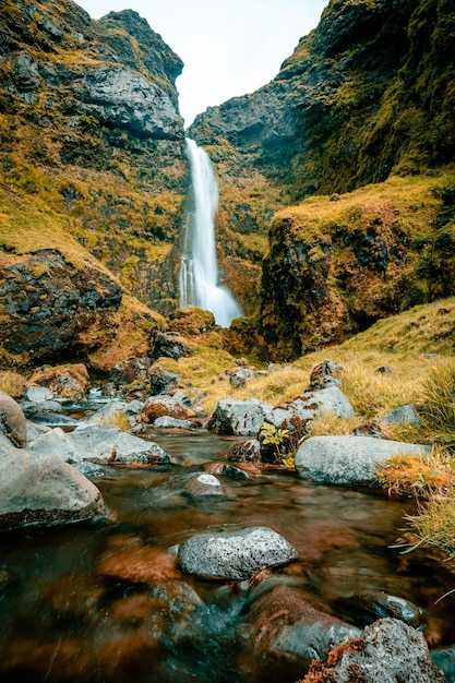 Una cascada en las montañas con un fondo verde