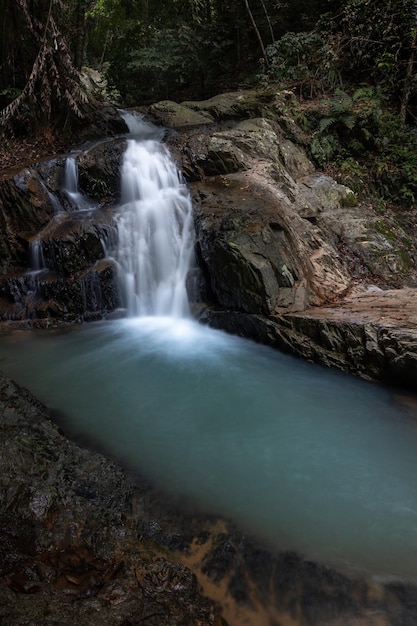 Cascada pintoresca de cascada se estrella en piscina azul entre paredes de granito Koh Samui Tailandia