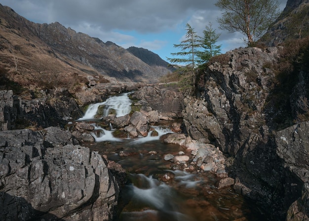 Cascada en el río rocoso coe y un abeto montaña glencoe escocia reino unido