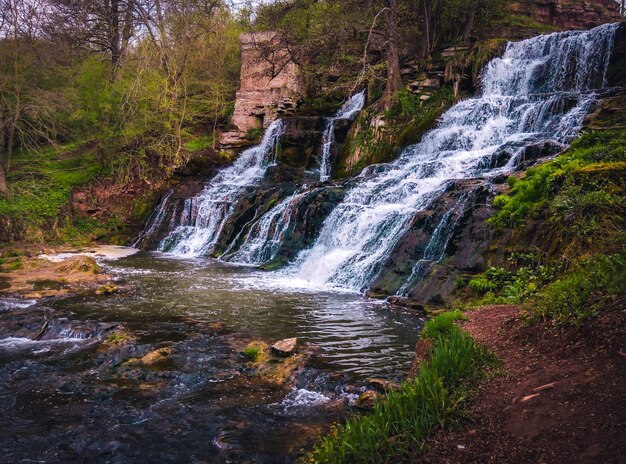 Foto una cascada con una roca en el medio