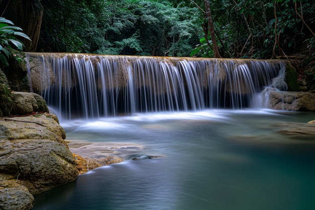 Cascada tranquila en un bosque exuberante con agua suave y sedosa que fluye sobre rocas rodeadas de vegetación