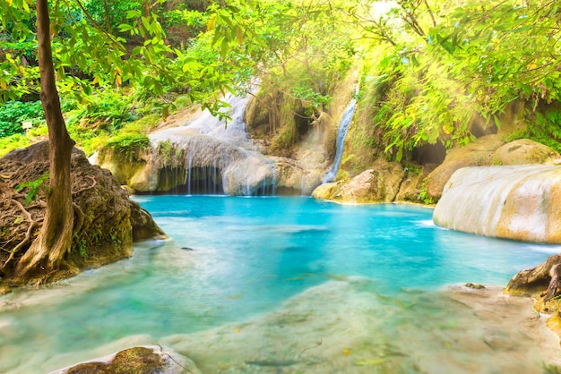 Cascada tropical con lago esmeralda y rocas en el bosque selvático