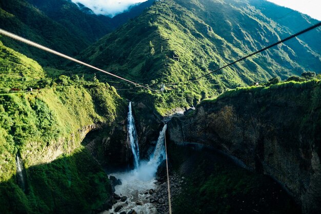 Foto las cascadas que ven la montaña verde foto de stock