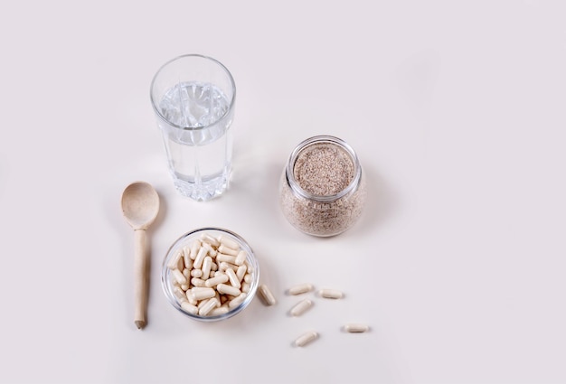 Cáscara y cápsulas de plátano macho y un vaso de agua.