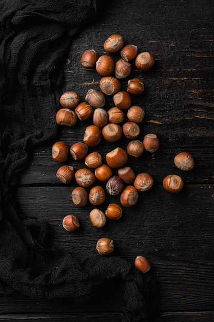 Cáscara de madera marrón avellanas sobre fondo de mesa de madera negra vista superior plana