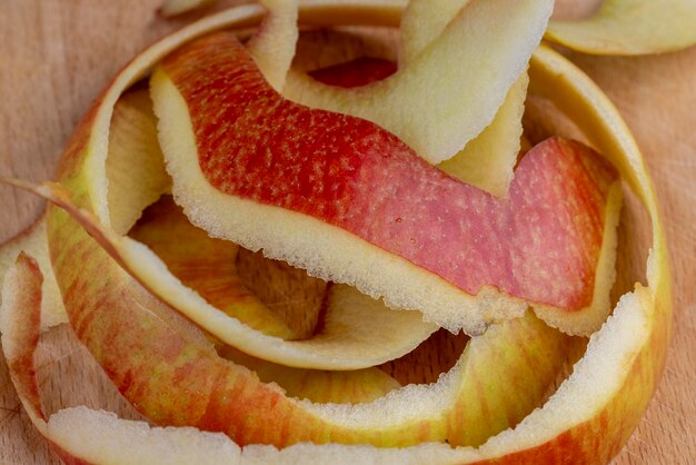 Foto la cáscara de una manzana pelada esparcida sobre el tablero.