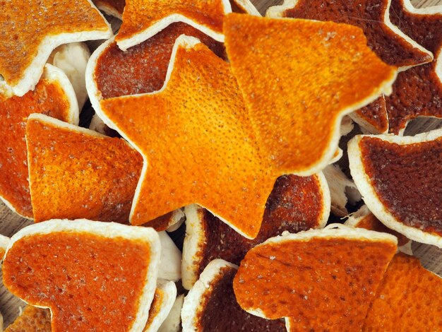 Foto cáscara de naranja seca en forma de corazones y estrellas como fondo