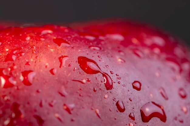 Foto cáscara roja de una manzana madura y jugosa con gotas de agua cerrar detalles de la cáscara de una variedad de manzana roja