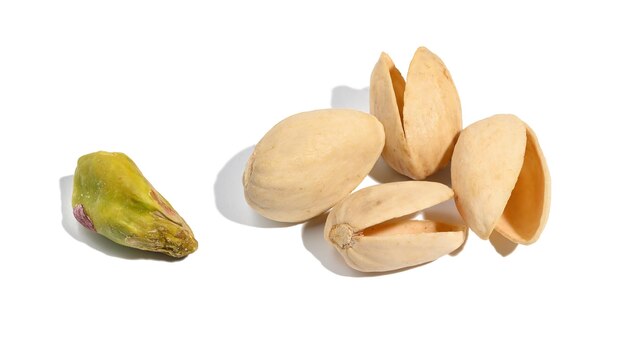 Cáscara vacía de pistachos tostados y núcleo sobre un fondo blanco aislado