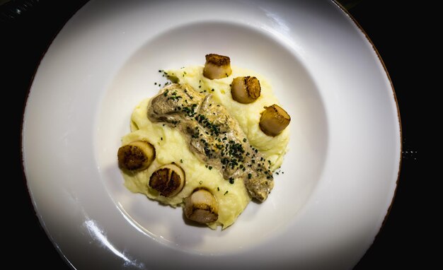 Cascas com creme de batata e cogumelos servidos no restaurante Prato branco