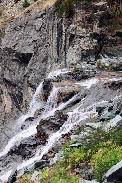 Cascatas espumantes cachoeiras alpinas rochas de granito texturizadas vegetação verde musgo vale de aosta