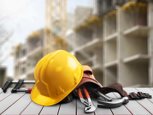 Casco amarillo con equipo sobre fondo de mesa de madera