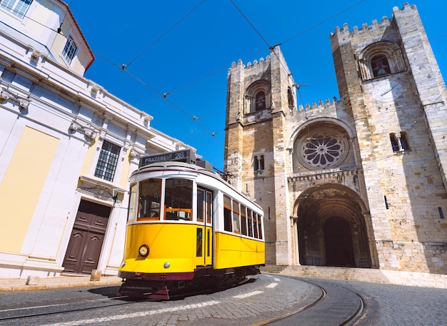 Foto casco antiguo de la ciudad de lisboa y el famoso tranvía amarillo 28 frente a la catedral de santa maría