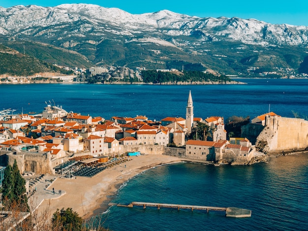 El casco antiguo de las montañas budva cubiertas de nieve.