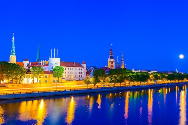 Casco antiguo de Riga con reflejo en el río Daugava por la noche Castillo de Riga Catedral de Riga Iglesia de San Pedro Riga Letonia