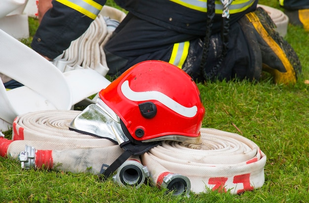 Casco de bombero sobre una manguera en la hierba