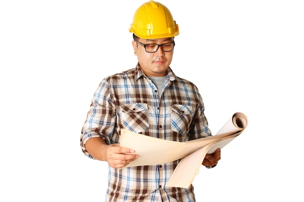 Un casco con un casco amarillo está leyendo para construir un edificio.