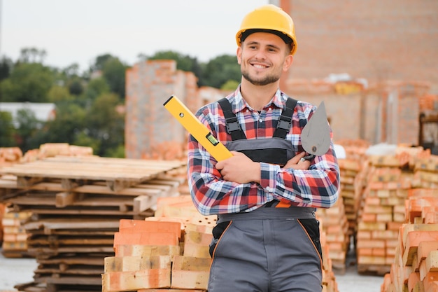 Casco de color amarillo Joven trabajando en uniforme en la construcción durante el día