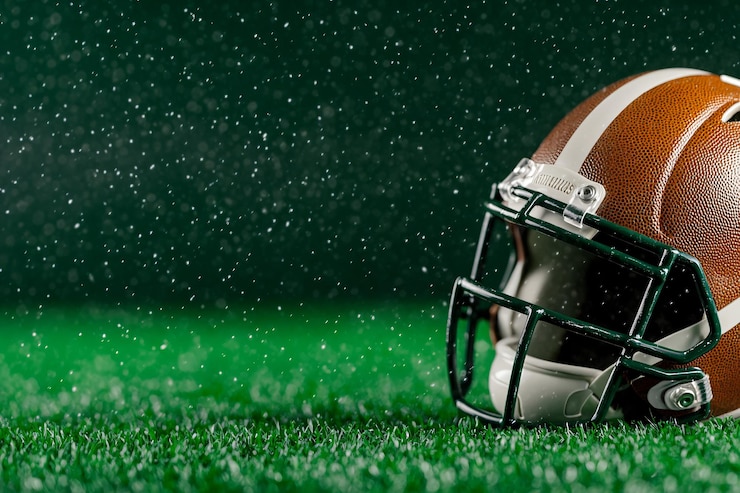 Casco de fútbol americano en un campo verde con lluvia